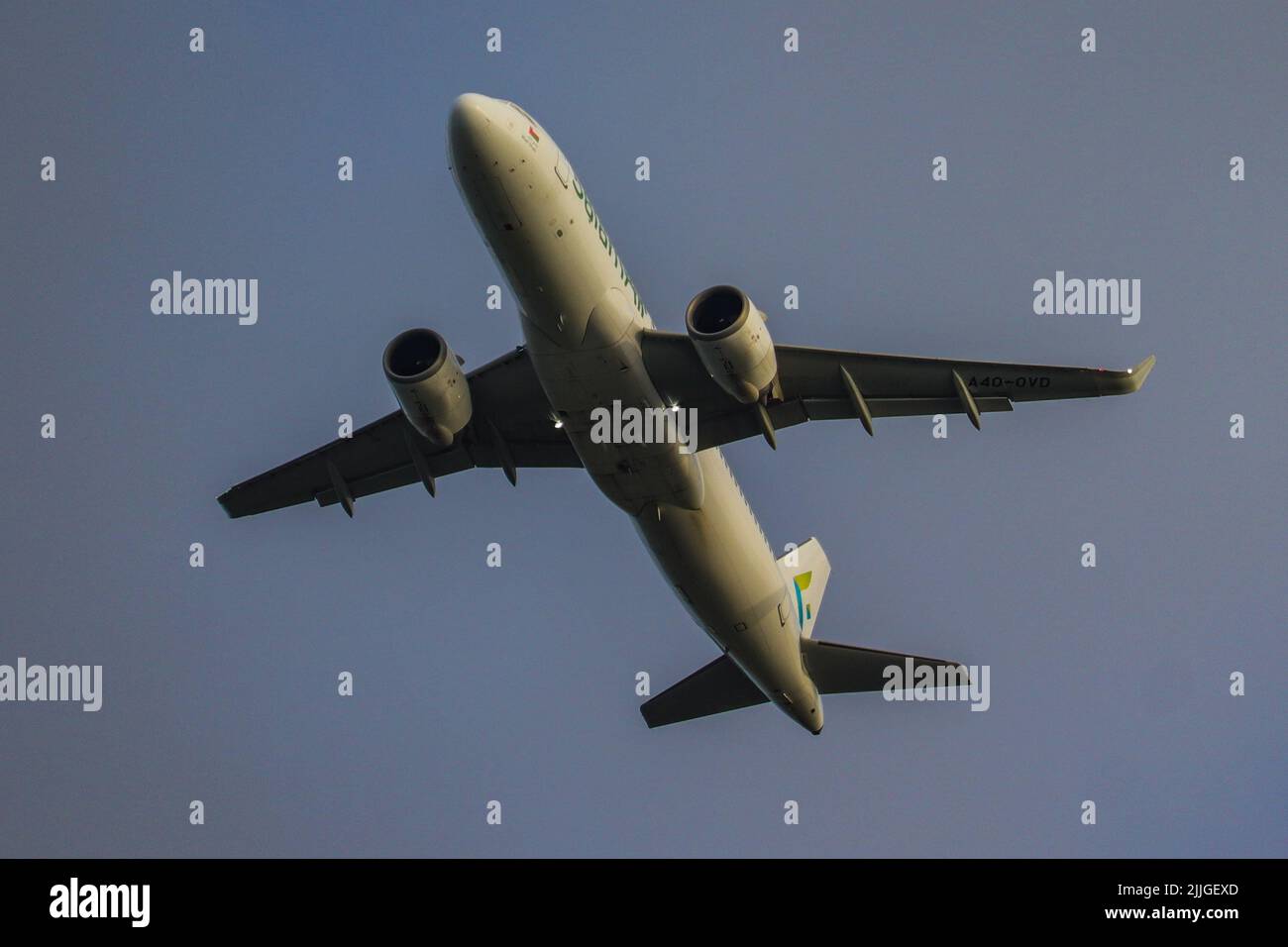 A flying airplane in the air with a cloudy sky background Stock Photo ...