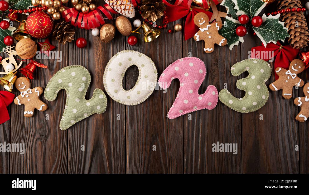 Colorful stitched digits 2023 of polkadot fabric with Christmas decorations flat lay  background on wooden table Stock Photo