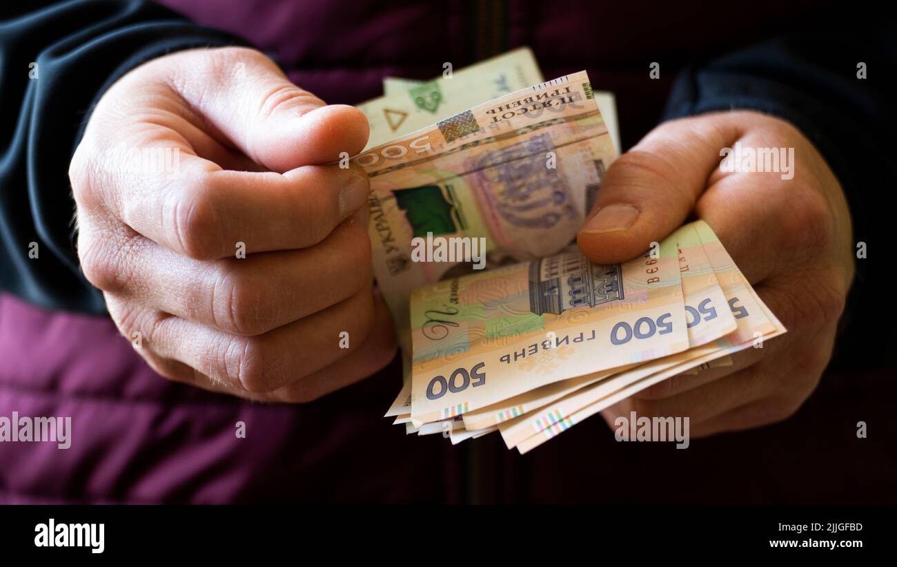 White male count Ukrainian hryvnia five hundred bills in his hands Stock Photo