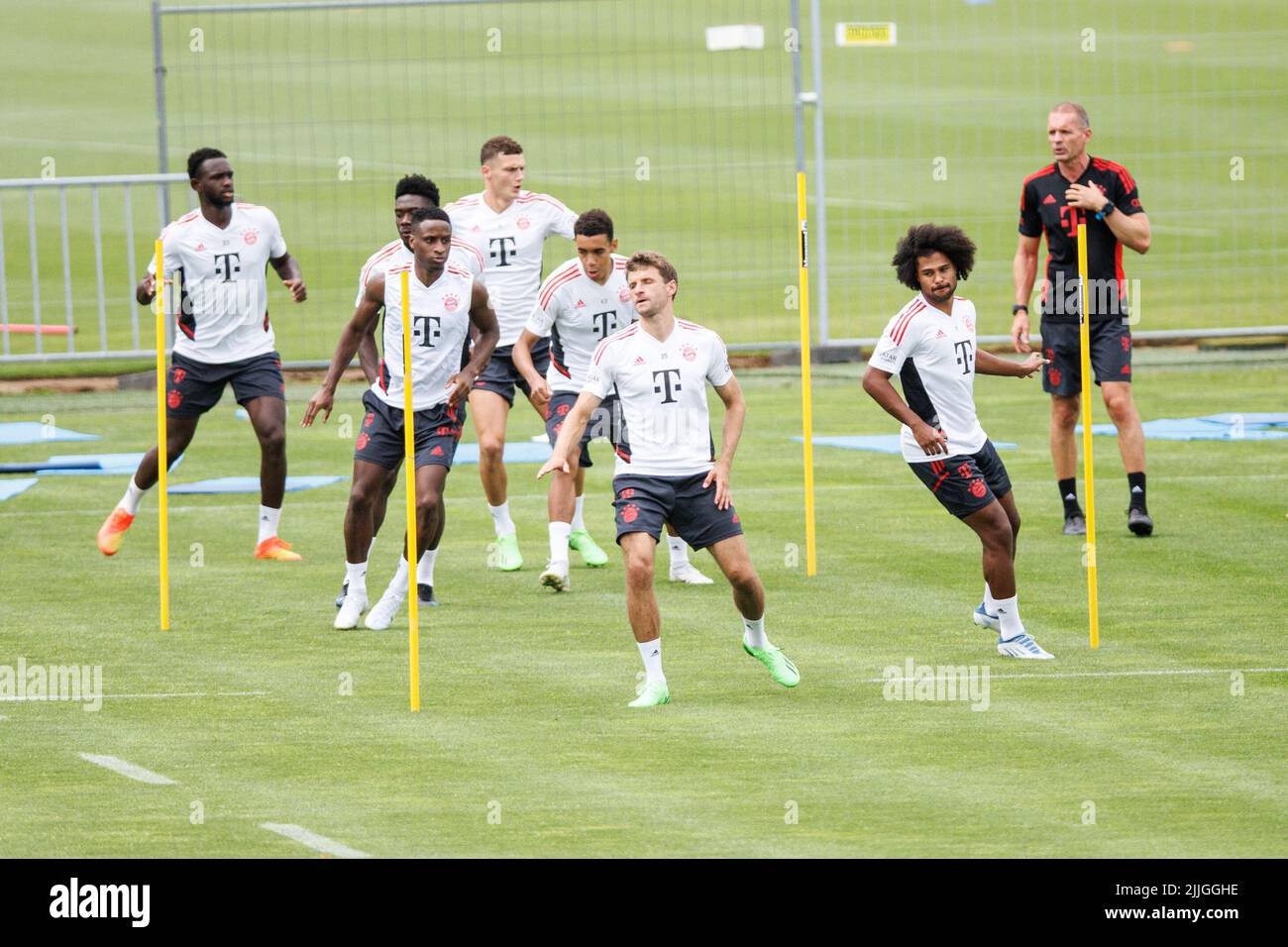 26 July 2022, Bavaria, Munich: Soccer: Bundesliga, training FC Bayern Munich before the Supercup at the training ground on Säbener Straße. Tanguy Nianzou (l-r), Alphonso Davies, Bouna Sarr, Benjamin Pavard, Jamal Musiala, Thomas Müller, and Serge Gnabry of FC Bayern München warm up. On the right is Holger Broich, fitness and rehabilitation coach of FC Bayern Munich. Photo: Matthias Balk/dpa - IMPORTANT NOTE: In accordance with the requirements of the DFL Deutsche Fußball Liga and the DFB Deutscher Fußball-Bund, it is prohibited to use or have used photographs taken in the stadium and/or of the Stock Photo