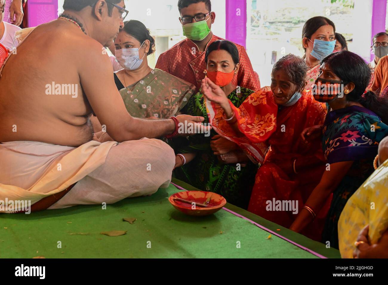 Howrah, West Bengal, India - 14th October 2021 : Hindu Purohit blessing devotees during pushpanjali puja to Goddess Durga, sacred ritual to worship th Stock Photo