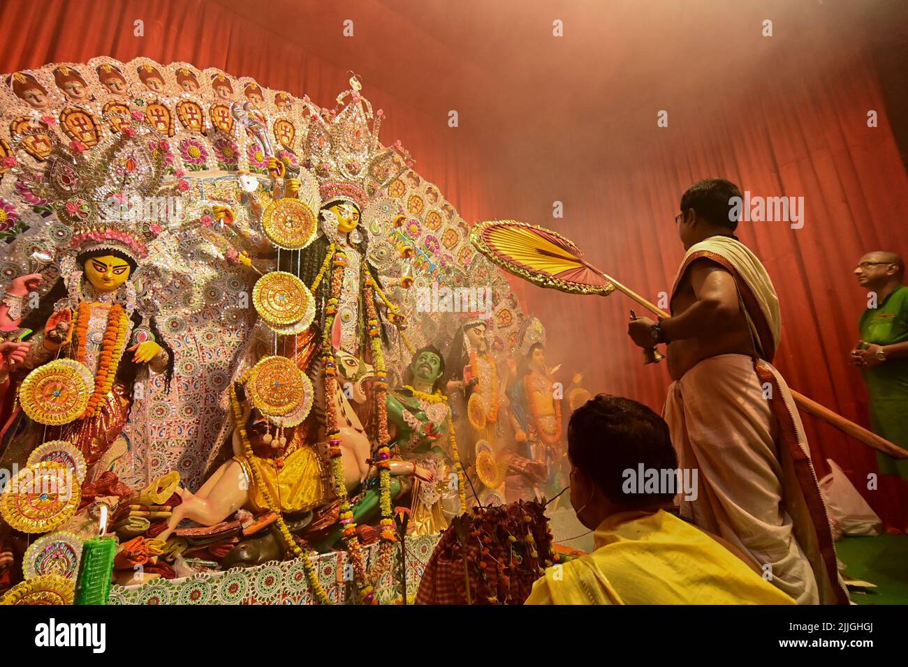 Howrah, India -October 13, 2021 : Hindu Priest worshipping Goddess Durga with ghanta and hand fan. Ashtami puja aarati - sacred Durga Puja ritual - sh Stock Photo