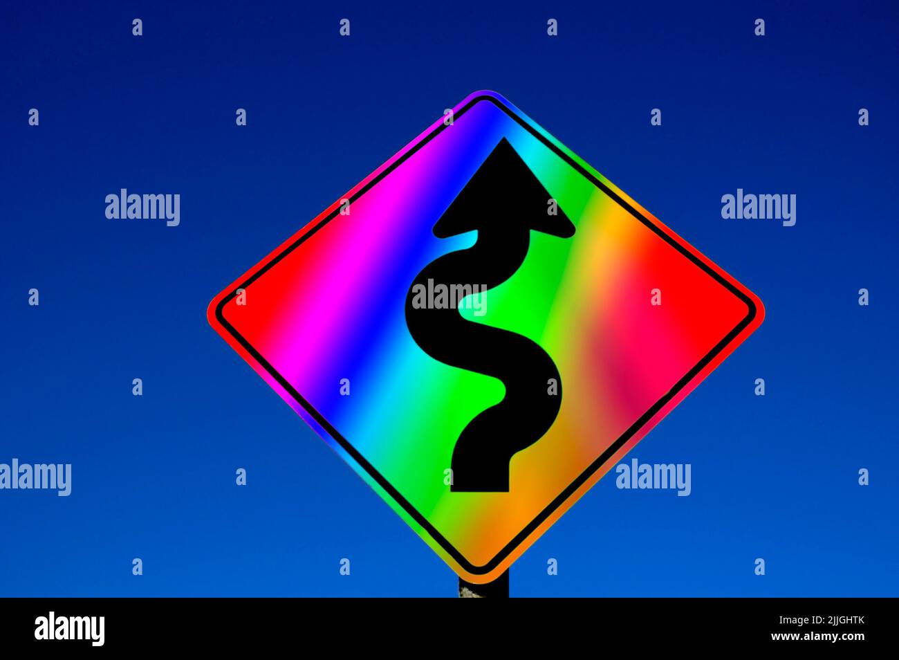 Gay Pride LGBTQ Rainbow colored street sign with curves against blue sky Stock Photo