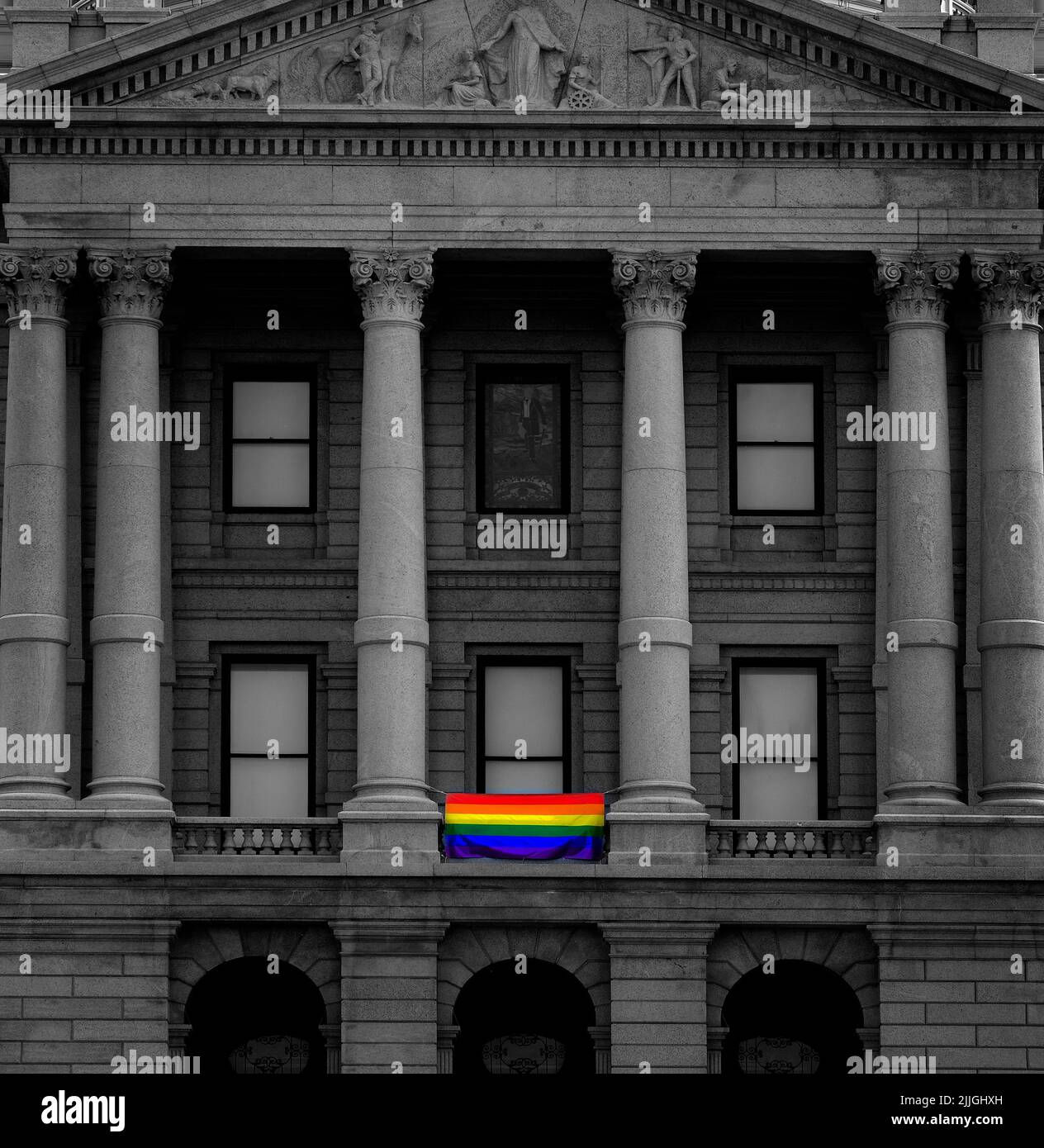 Government building displaying a Pride flag for LGBTQ rights and acceptance Stock Photo