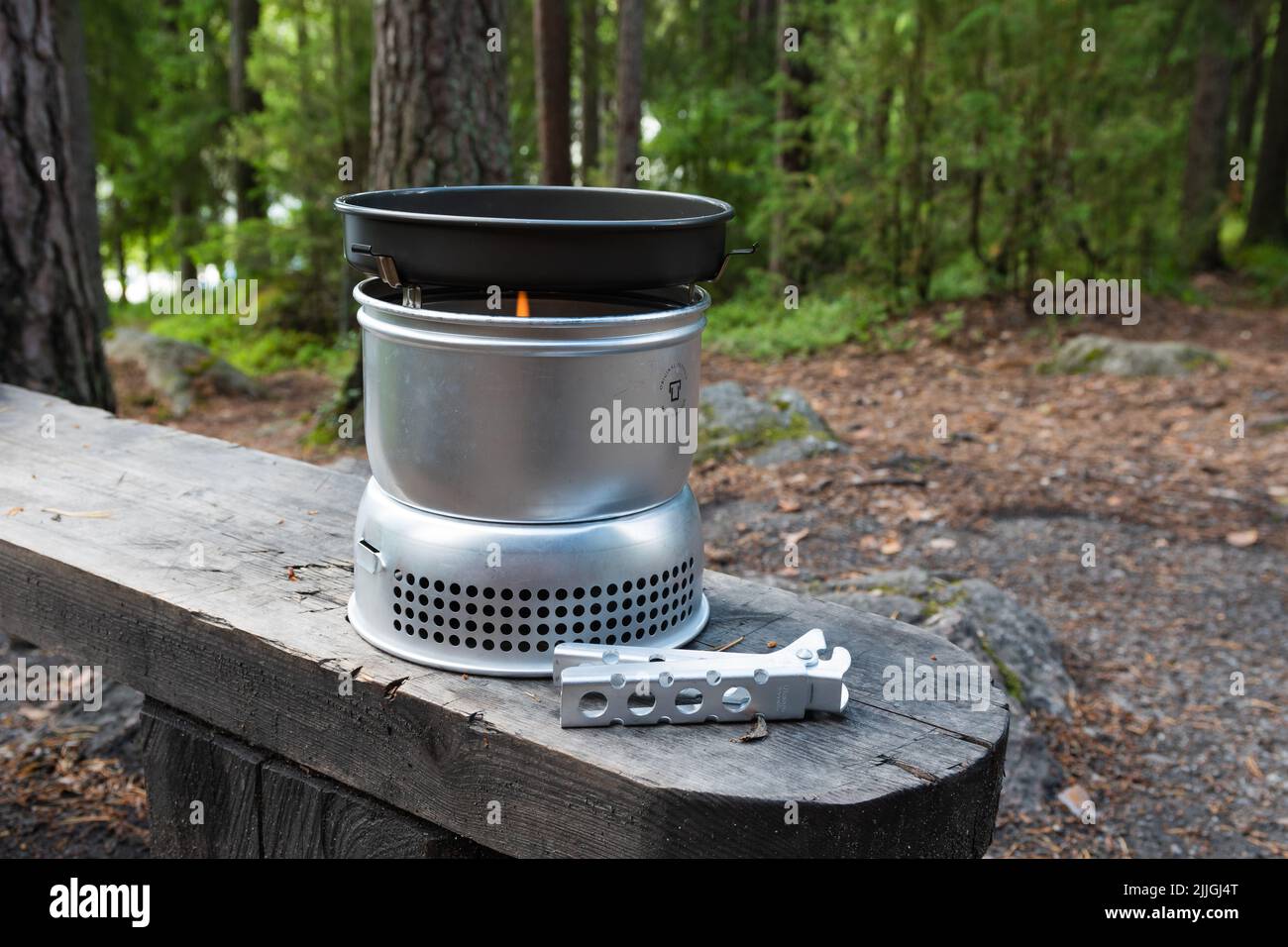 Hameenlinna, Finland. July 10, 2022. Trangia, the portable camping stove on a bench in a forest Stock Photo