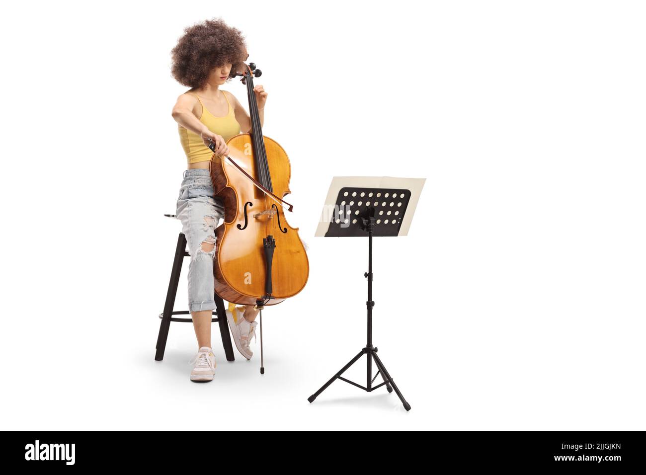 Young female sitting on a chair and playing a contrabass with a music sheet a stand isolated on white background Stock Photo