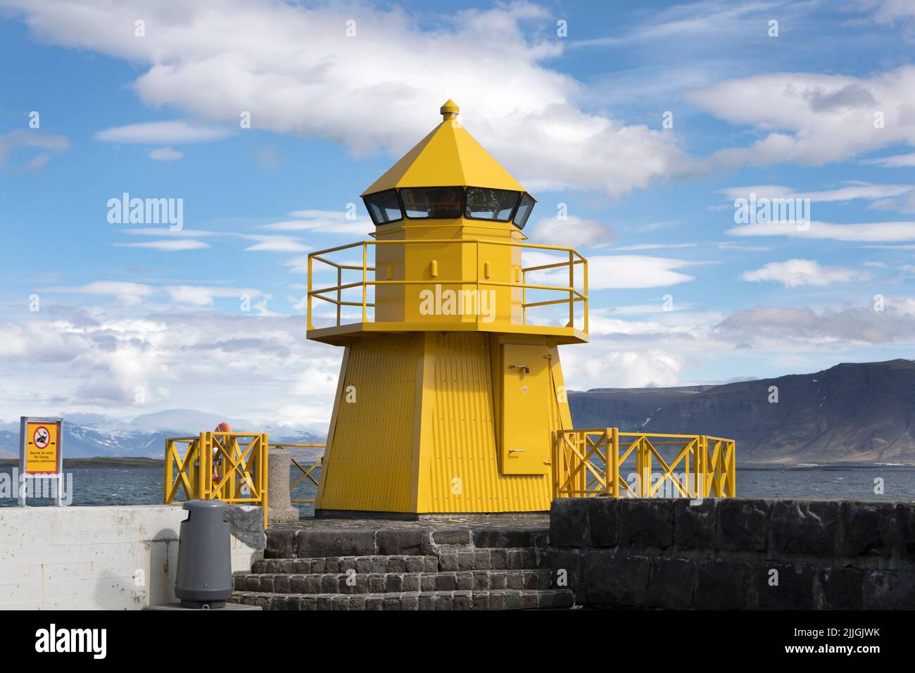 Small yellow Harbour Lighthouse at the entrance to Reykjavik harbour, Iceland Stock Photo