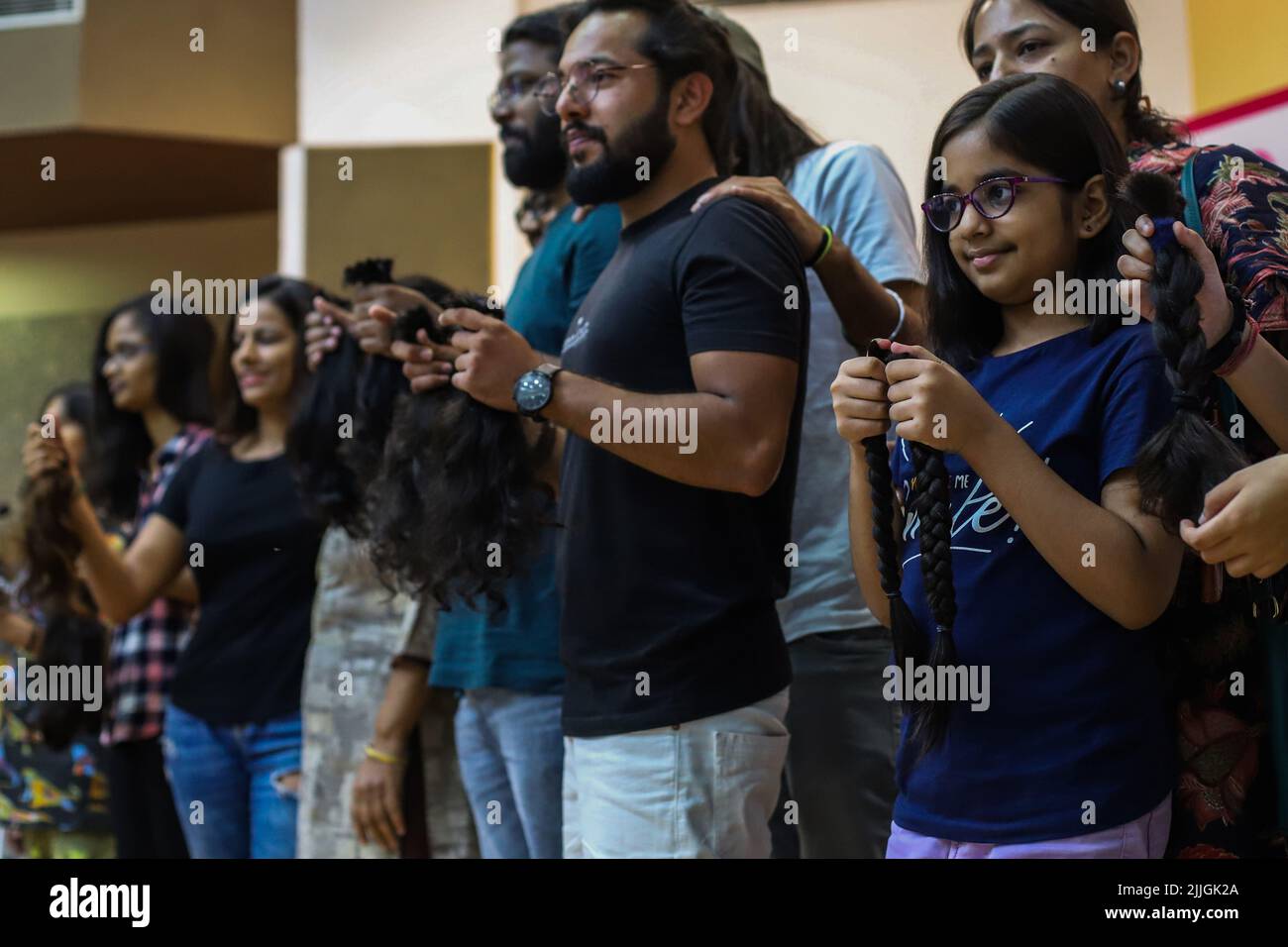 New Delhi, India. 24th July, 2022. Volunteers show their hair locks after  snipping off during a donation drive to support cancer survivors, organized  by Hair for Hope India foundation's Cut-a-thon event in