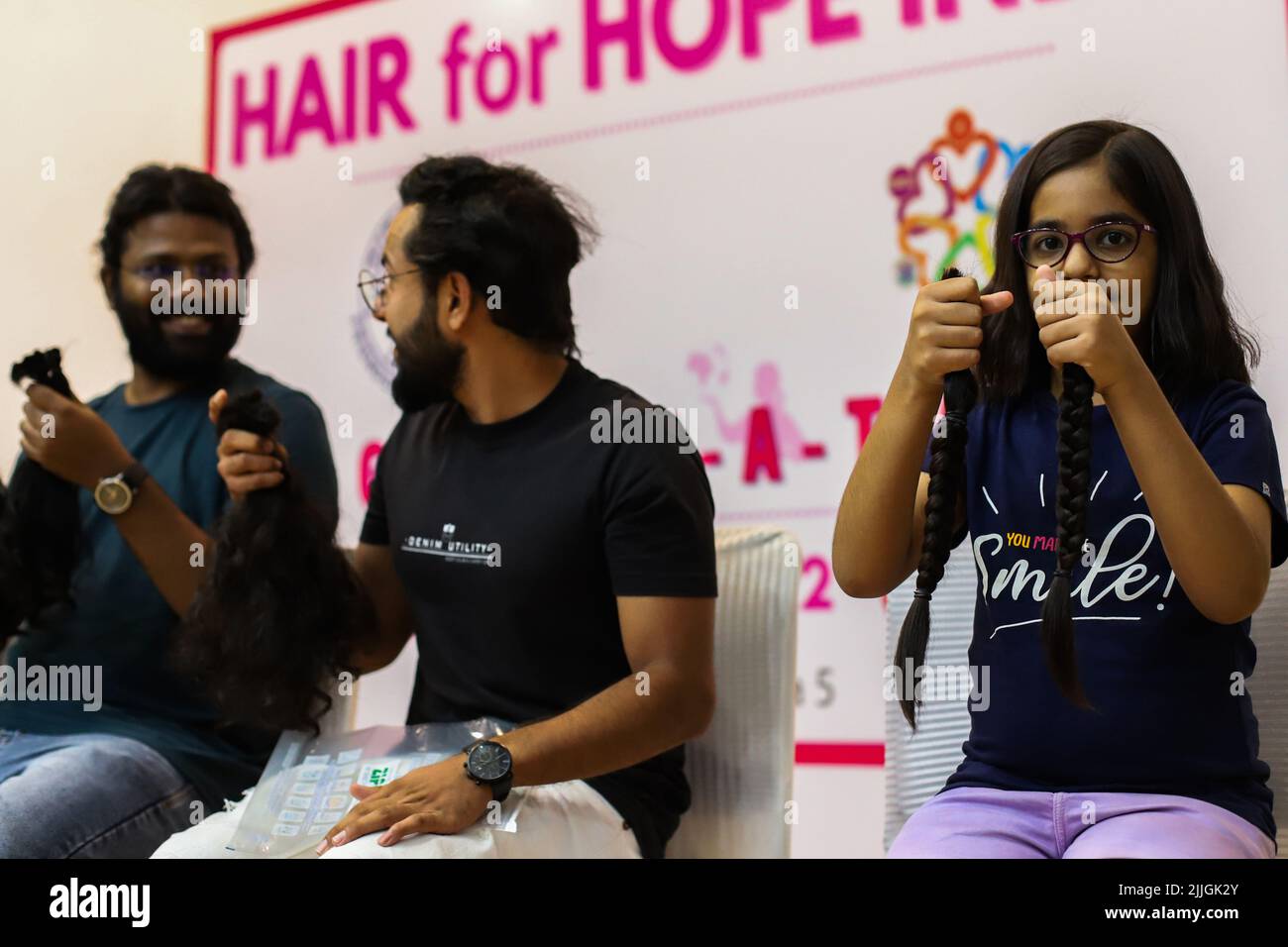 New Delhi, India. 24th July, 2022. A young volunteer shows her hair locks  after snipping off during a donation drive to support cancer survivors,  organized by Hair for Hope India foundation's Cut-a-thon