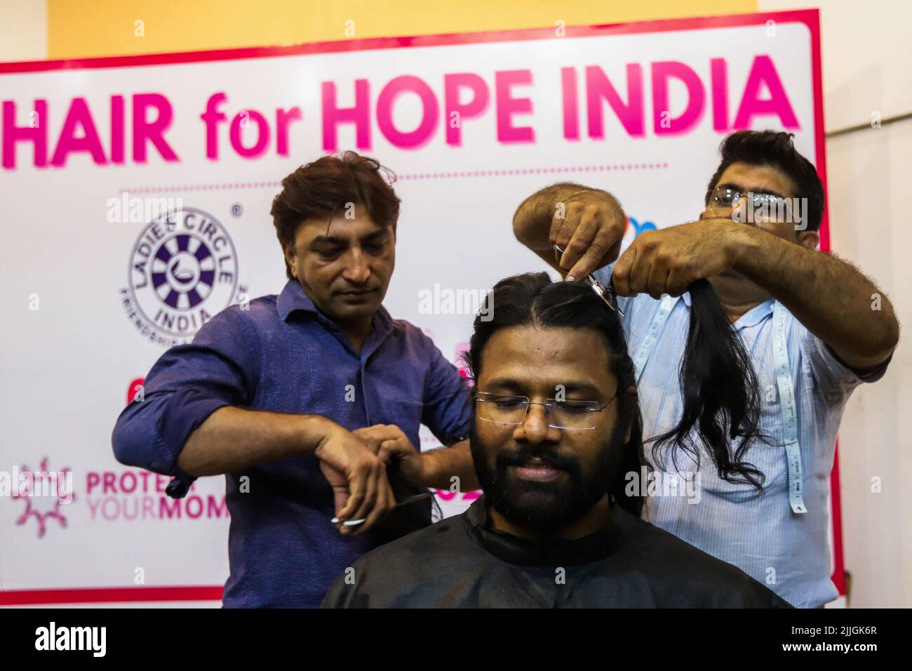 Hairdressers prepare the hair of a youth donor before snipping off during a  donation drive to support cancer survivors, organized by Hair for Hope  India foundation's Cut-a-thon event in New Delhi. As