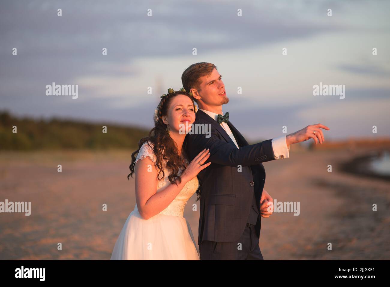 The view of the bride and groom posing on the seashore at sunset Stock ...