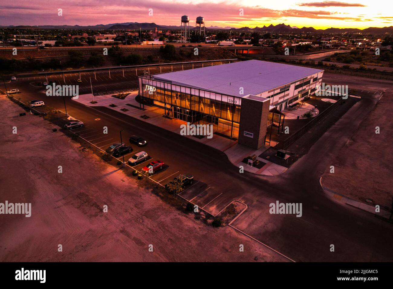 An aerial view of a beautiful modern building with a parking lot during