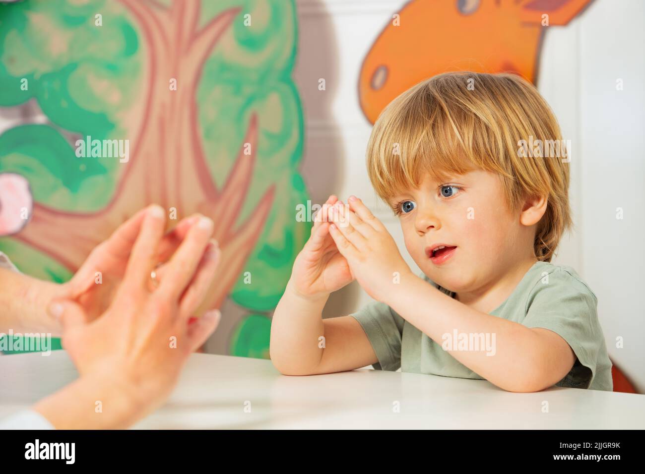 Little boy in development finger game class with therapist Stock Photo
