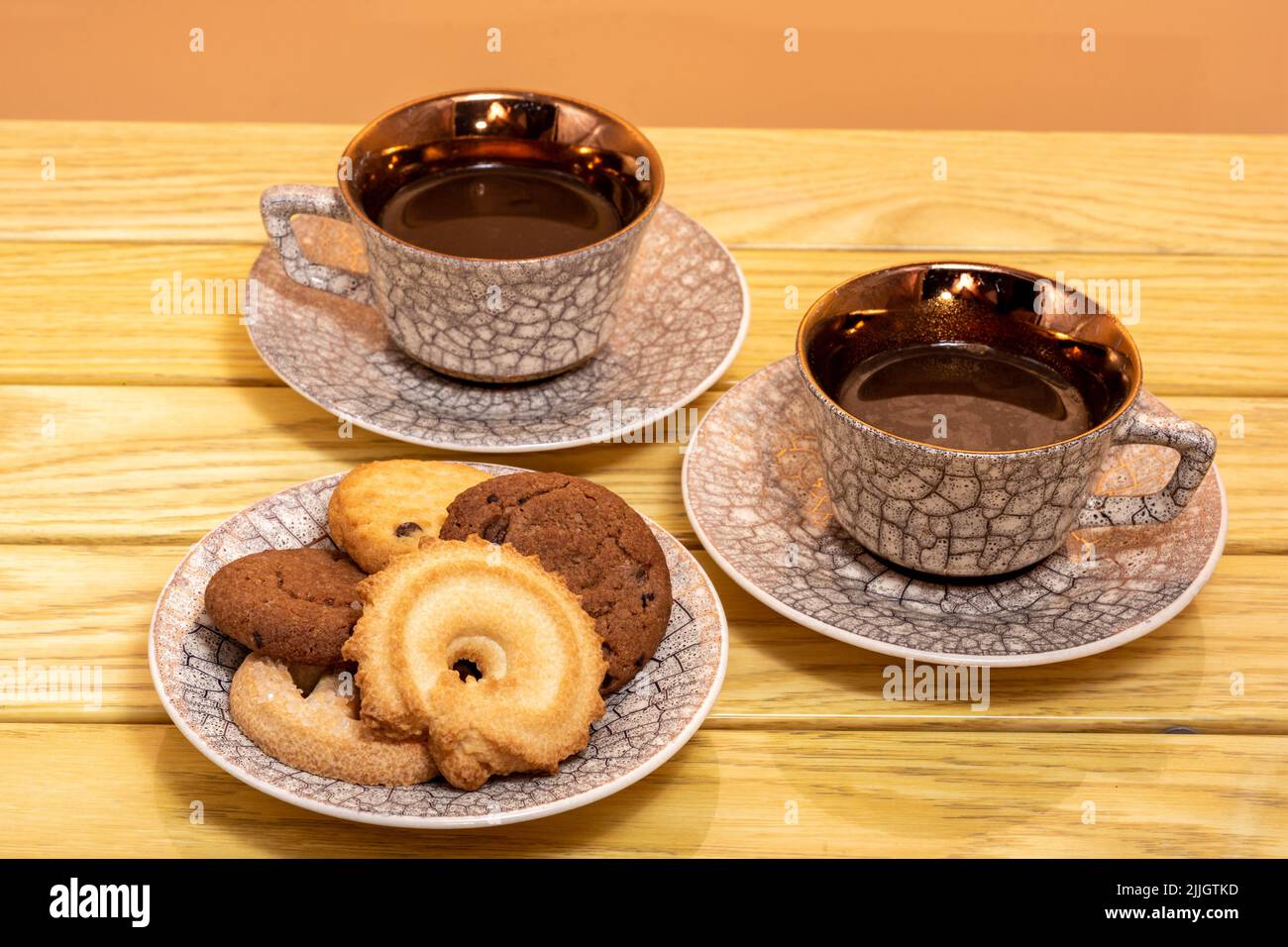 cups of latte and cookies on wooden table Stock Photo