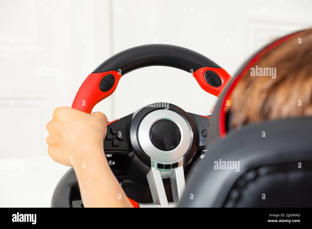 Children's hands on pc gaming wheel view from behind Stock Photo