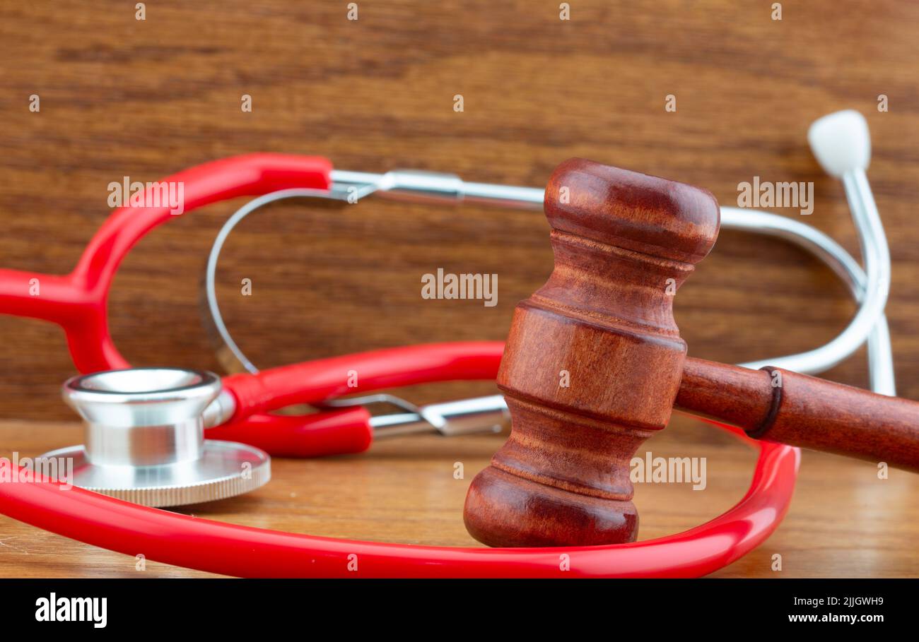 Wood gavel and red stethoscope are symbols of choices within legal, personal, and medical in medicine, politics, and business Stock Photo