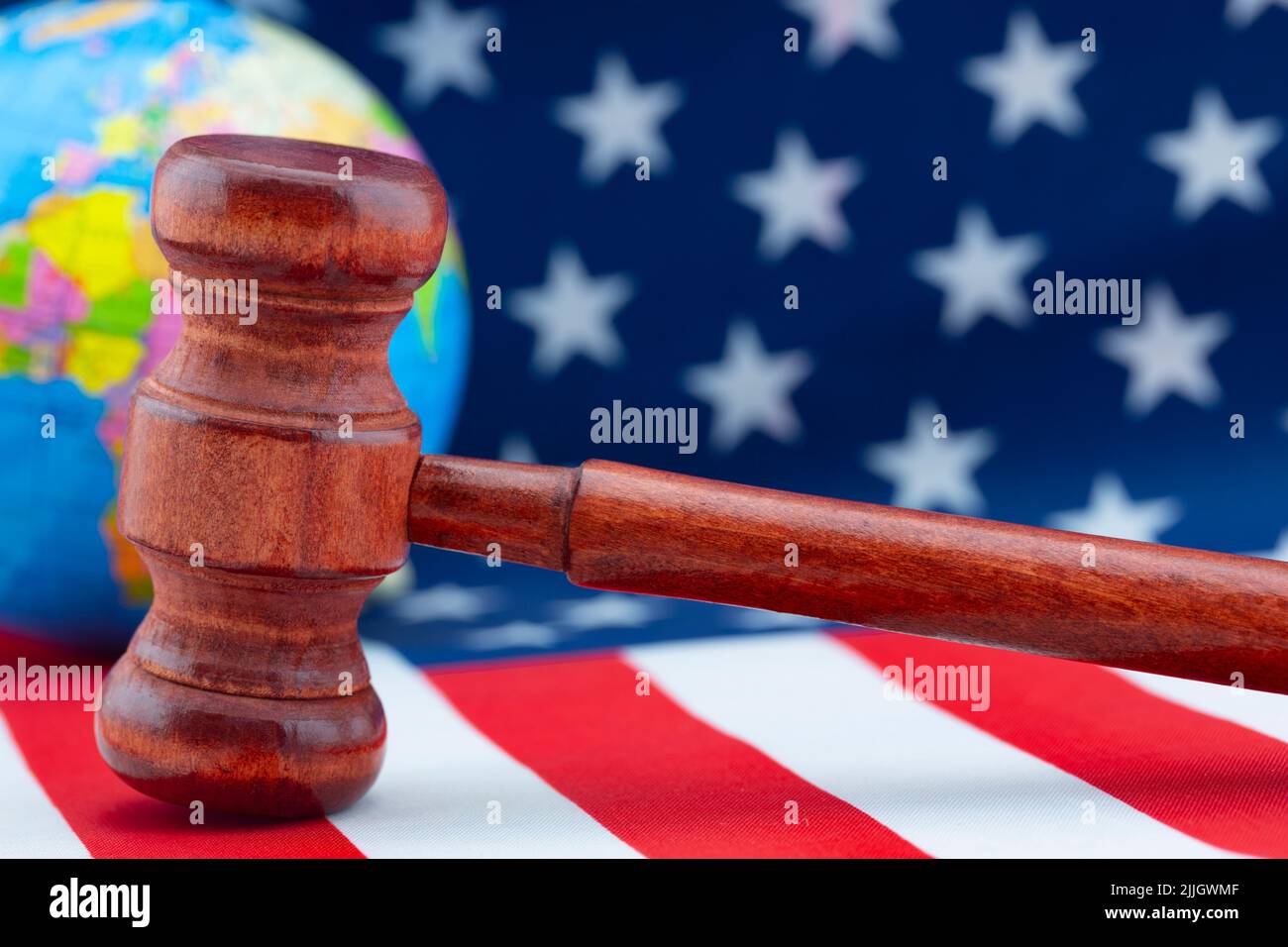 Concept of American justice and laws working in global environment reflected in symbols of gavel, flag, and globe Stock Photo