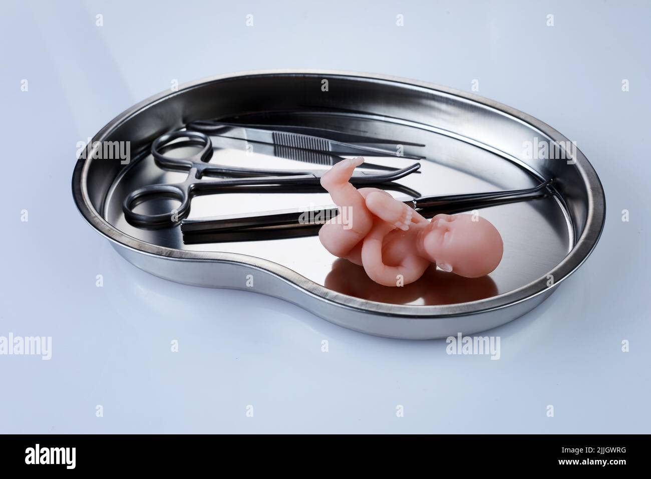 Abortion concept. Baby doll near medical instruments Stock Photo