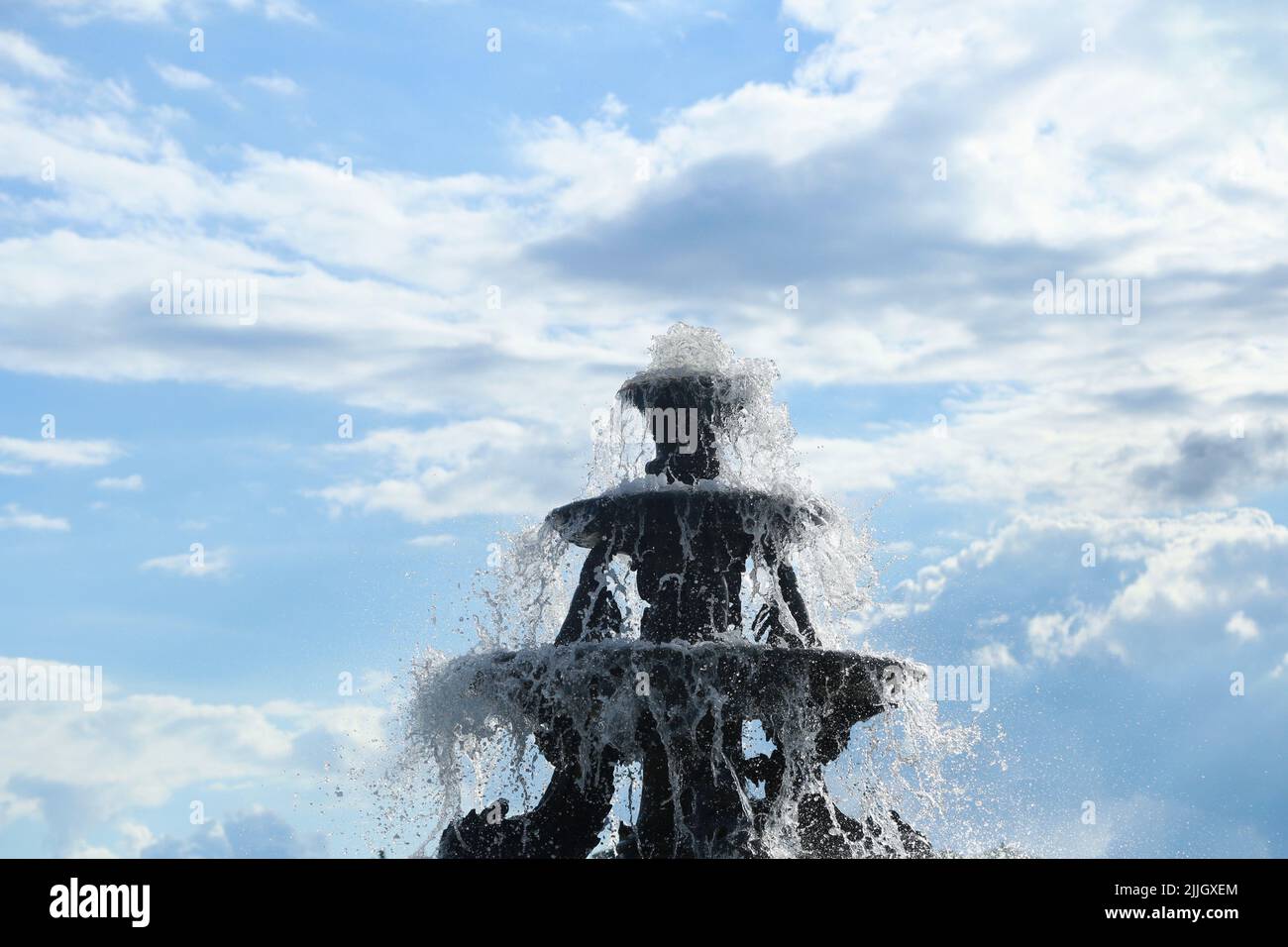 A water fountain against blue cloudy sky Stock Photo - Alamy