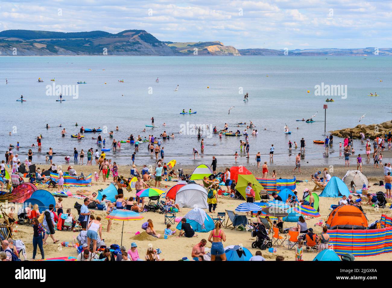 Lyme Regis, Dorset, UK. 26th July, 2022. UK Weather: Families and staycationers soak up the lovely warm sunshine at the seaside resort of Lyme Regis. Holidaymakers are set to more enjoy more glorious weather as hot and sunny weather makes a welcome return towards the weekend. Credit: Celia McMahon/Alamy Live News Stock Photo