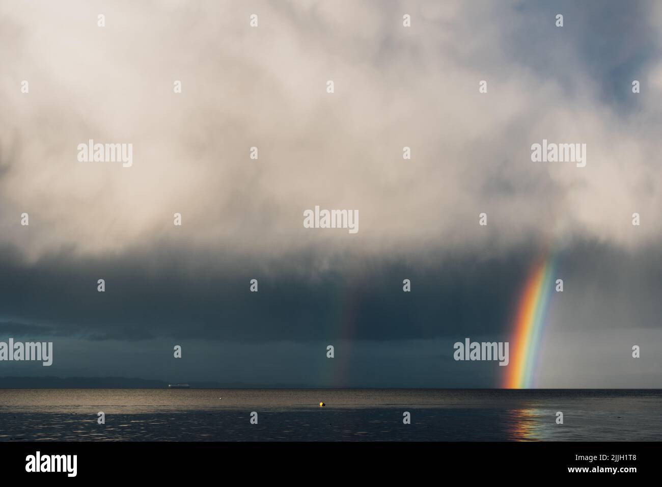 gray clouds with rainbow over the sea ocean Stock Photo - Alamy