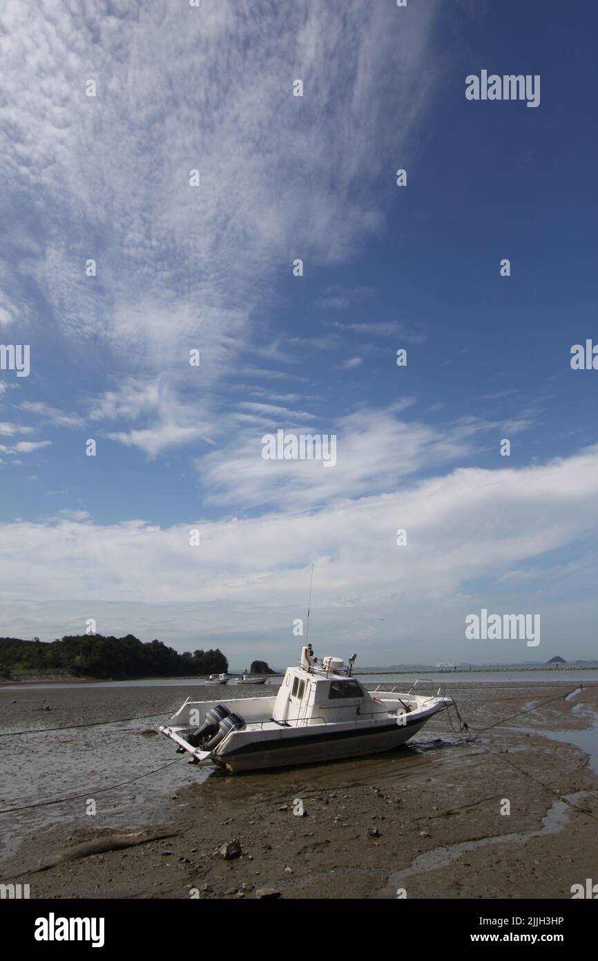 A vertical shot of a boat parked on a wet sand Stock Photo - Alamy
