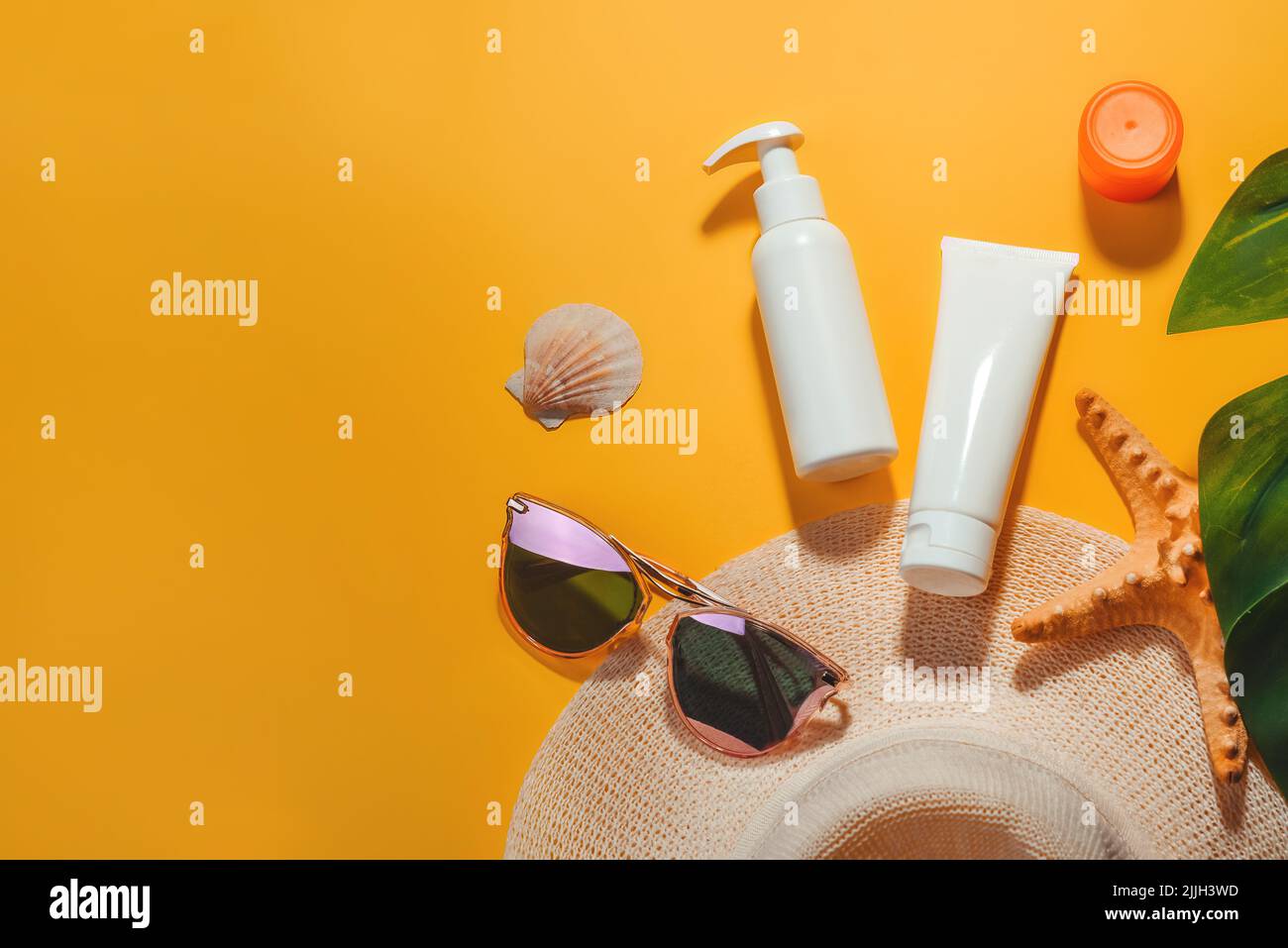 Set of accessories for sun protection on beach sunglasses, cosmetics, SPF cream Stock Photo