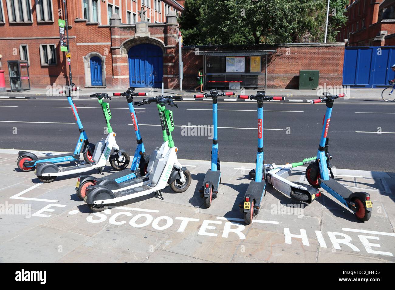 ELECTRIC SCOOTERS IN AN E-SCOOTER HIRE PARKING BAY ON A LONDON STREET Stock Photo