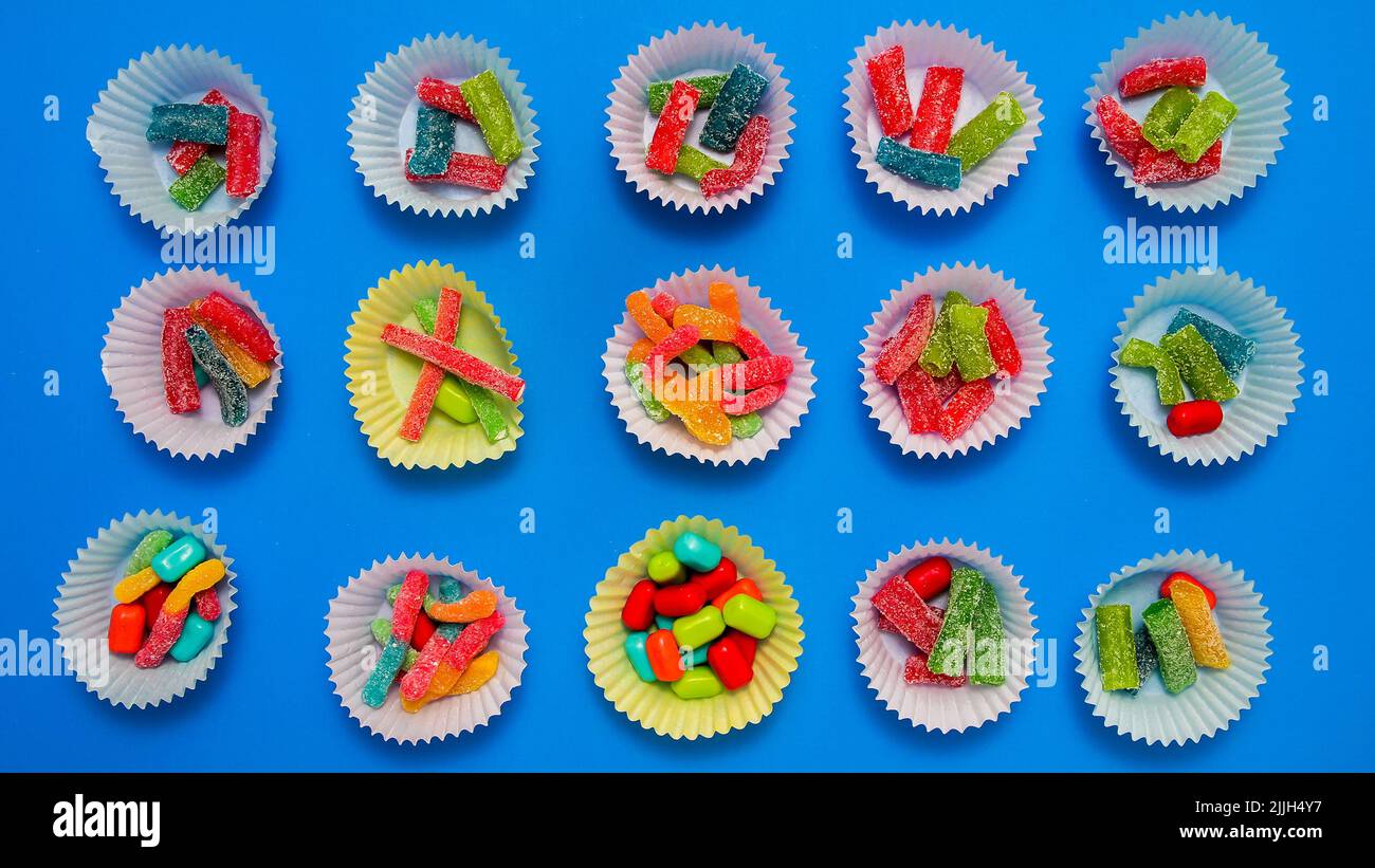 Various candy inside baking cups with with blue background Stock Photo