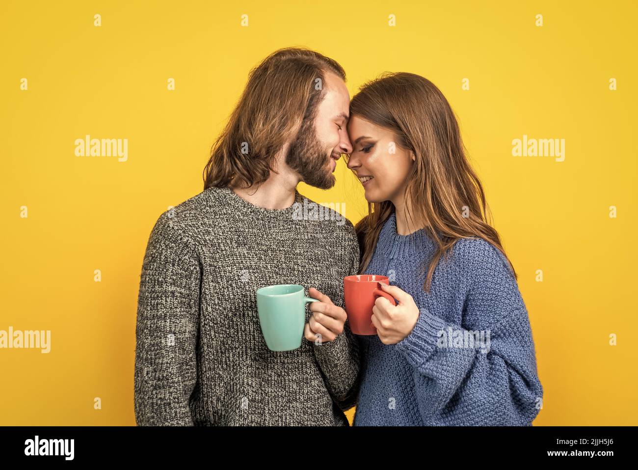 happy family couple wear knitted clothes in winter and drinking hot