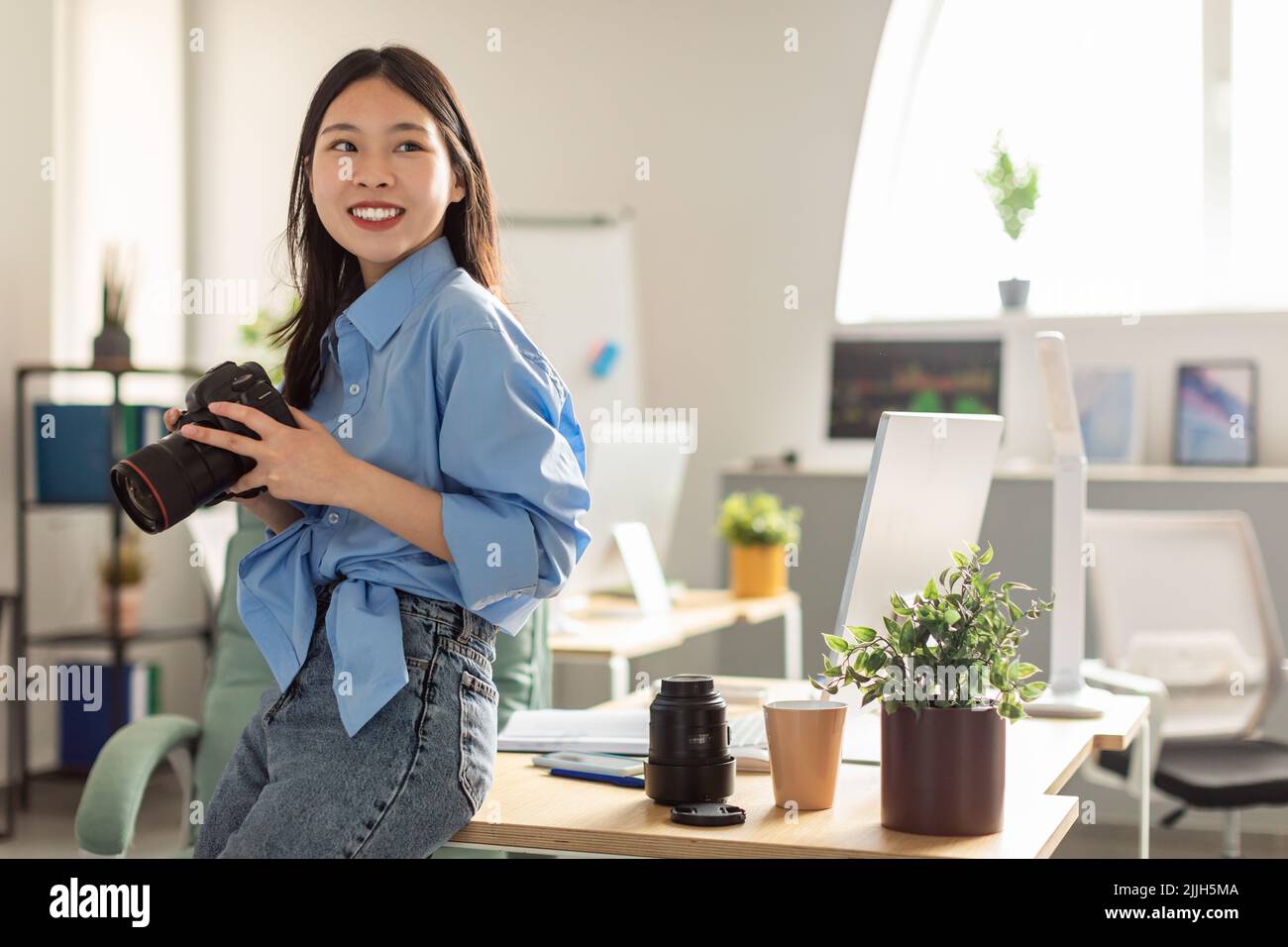 Cheerful Japanese Millennial Photographer Woman Holding Photocamera Posing Indoor Stock Photo