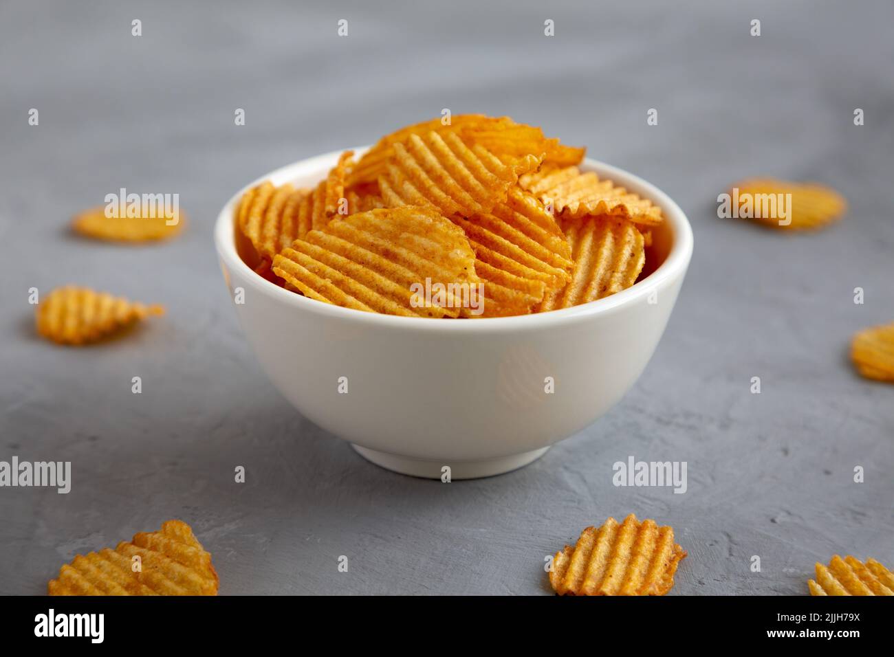 Crispy Barbeque Potato Chips in a Bowl on a gray background, side view