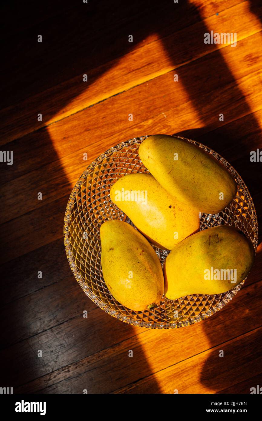 yellow champagne mango fruit in crystal bowl Stock Photo Alamy