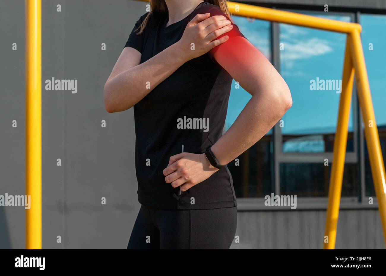 Athlete touching painful shoulder with red point during outdoor training. Dislocation, arthritis, fracture, rotator cuff strain consequences. Health problems in sport concept. High quality photo Stock Photo