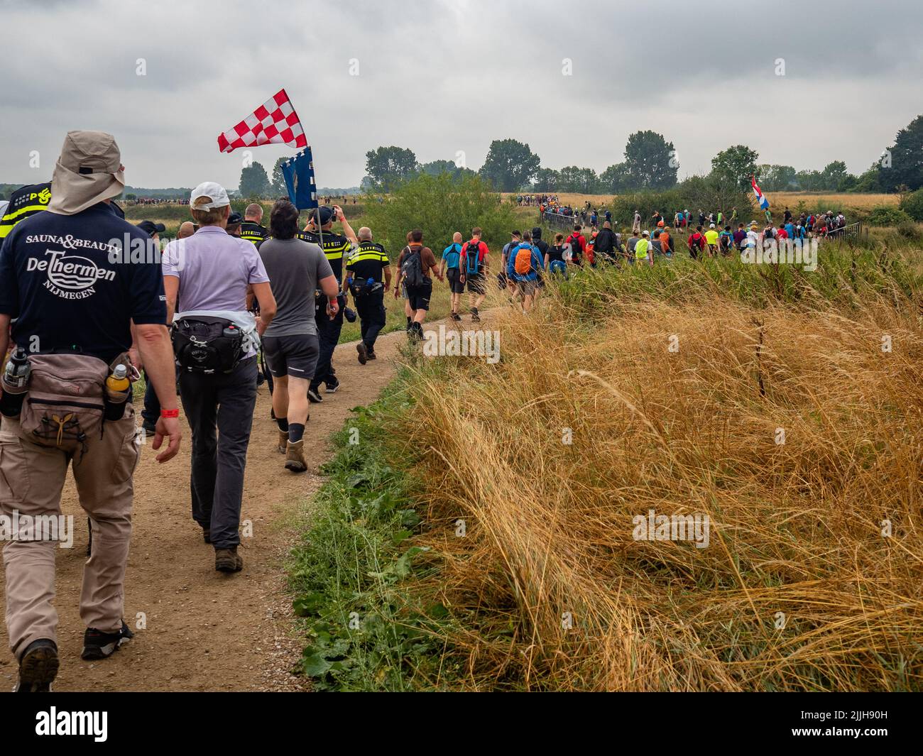 Participants are seen walking through a natural park during the world’s biggest multi-day walking event. The Four Days March (in Dutch 'Vierdaagse') is seen as the prime example of sportsmanship and international bonding between military servicemen and civilians from many different countries. After two years of cancellations, it was held again, but the first day was canceled due to warm temperatures, turning the four marches into three days marches. This is the 104 edition and the official total of walkers registered was 38,455 from 69 countries. They can choose to walk 30km, 40km, or 50km per Stock Photo