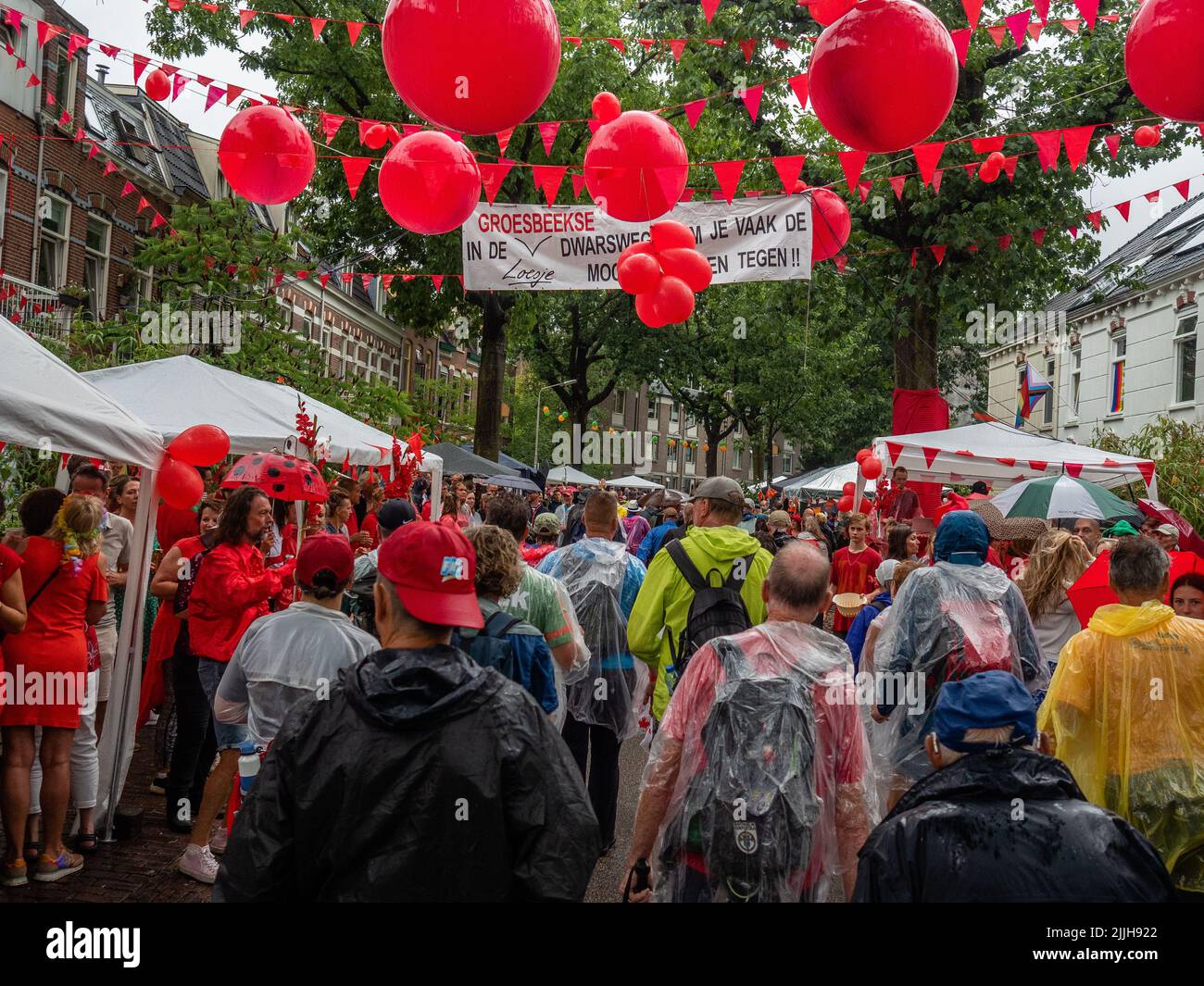 Participants arrive at a neighborhood decorated with red balloons during the world’s biggest multi-day walking event. The Four Days March (in Dutch 'Vierdaagse') is seen as the prime example of sportsmanship and international bonding between military servicemen and civilians from many different countries. After two years of cancellations, it was held again, but the first day was canceled due to warm temperatures, turning the four marches into three days marches. This is the 104 edition and the official total of walkers registered was 38,455 from 69 countries. They can choose to walk 30km, 40km Stock Photo
