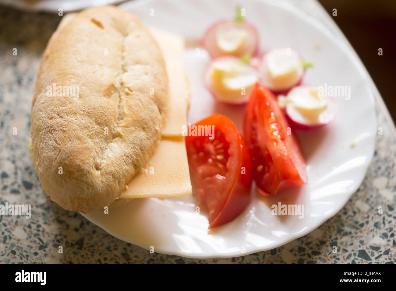 Bun with cheese, tomatoes, radishes with butter Stock Photo Alamy