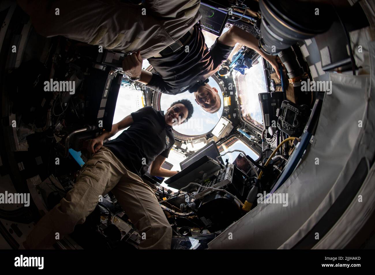 NASA astronauts Bob Hines and Jessica Watkins monitor the docking of SpaceX Dragon space freighter from inside the cupola onboard the International Space Station, July 16, 2022 in Earth Orbit. Stock Photo