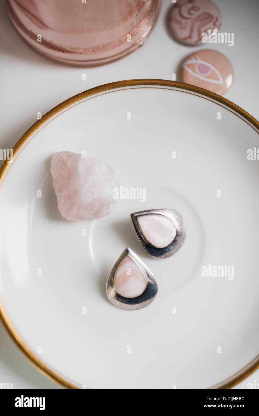 pink rose quartz and sterling silver teardrop earrings with rose quartz on white plate Stock Photo