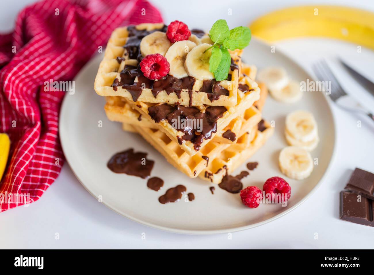 delicious belgian breakfast waffles with strawberries and raspberries and chocolate and banana Stock Photo