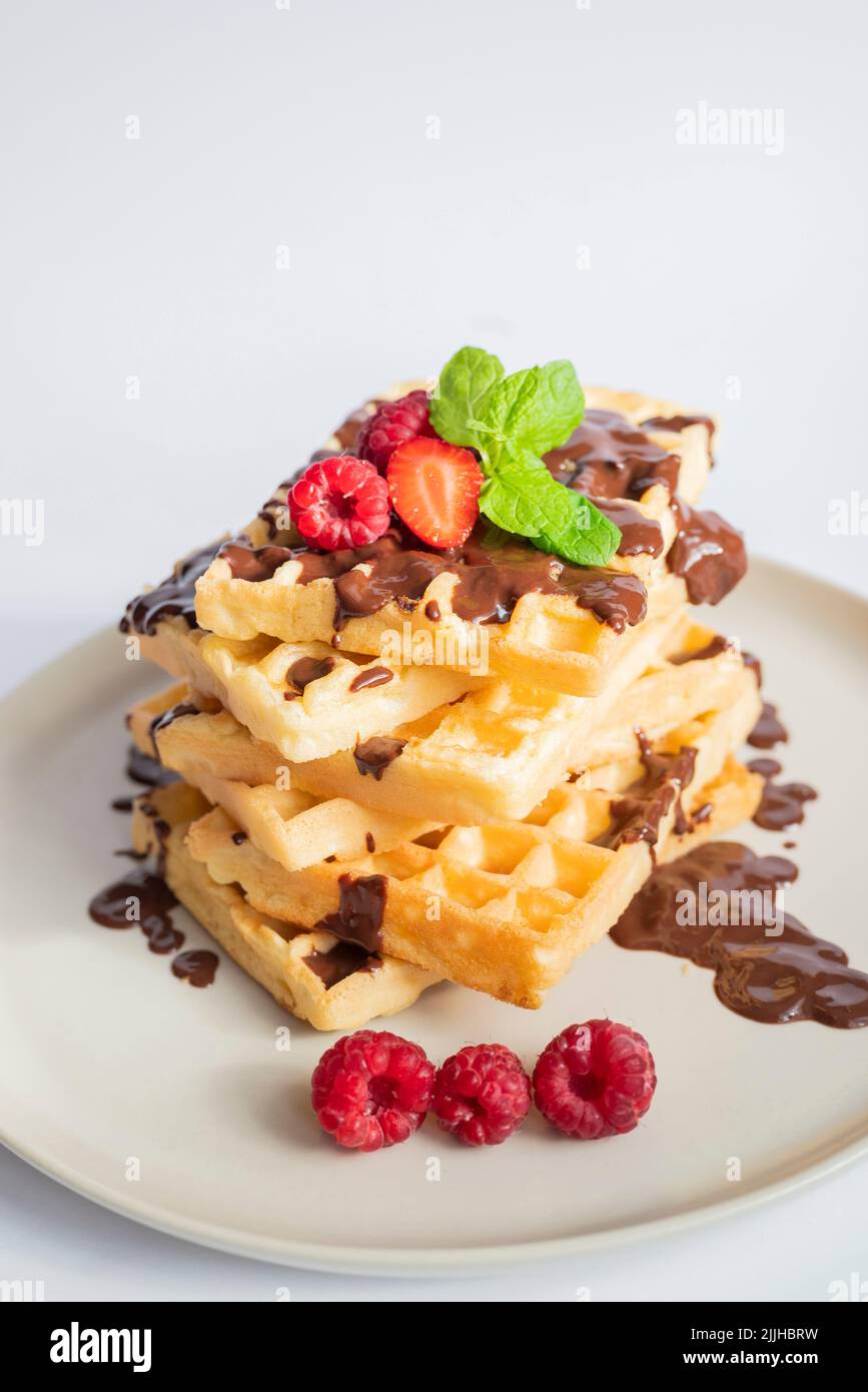 delicious belgian waffles for breakfast with strawberries and raspberries and chocolate Stock Photo