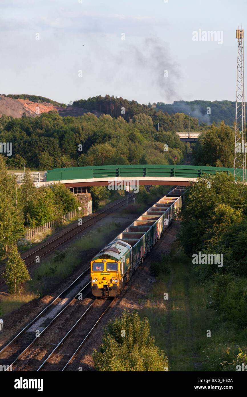 Freightliner class 66 diesel locomotive passing Bennerley in the Erewash valley, Nottinghamshire, UK with a freight train of empty aggregates wagons Stock Photo