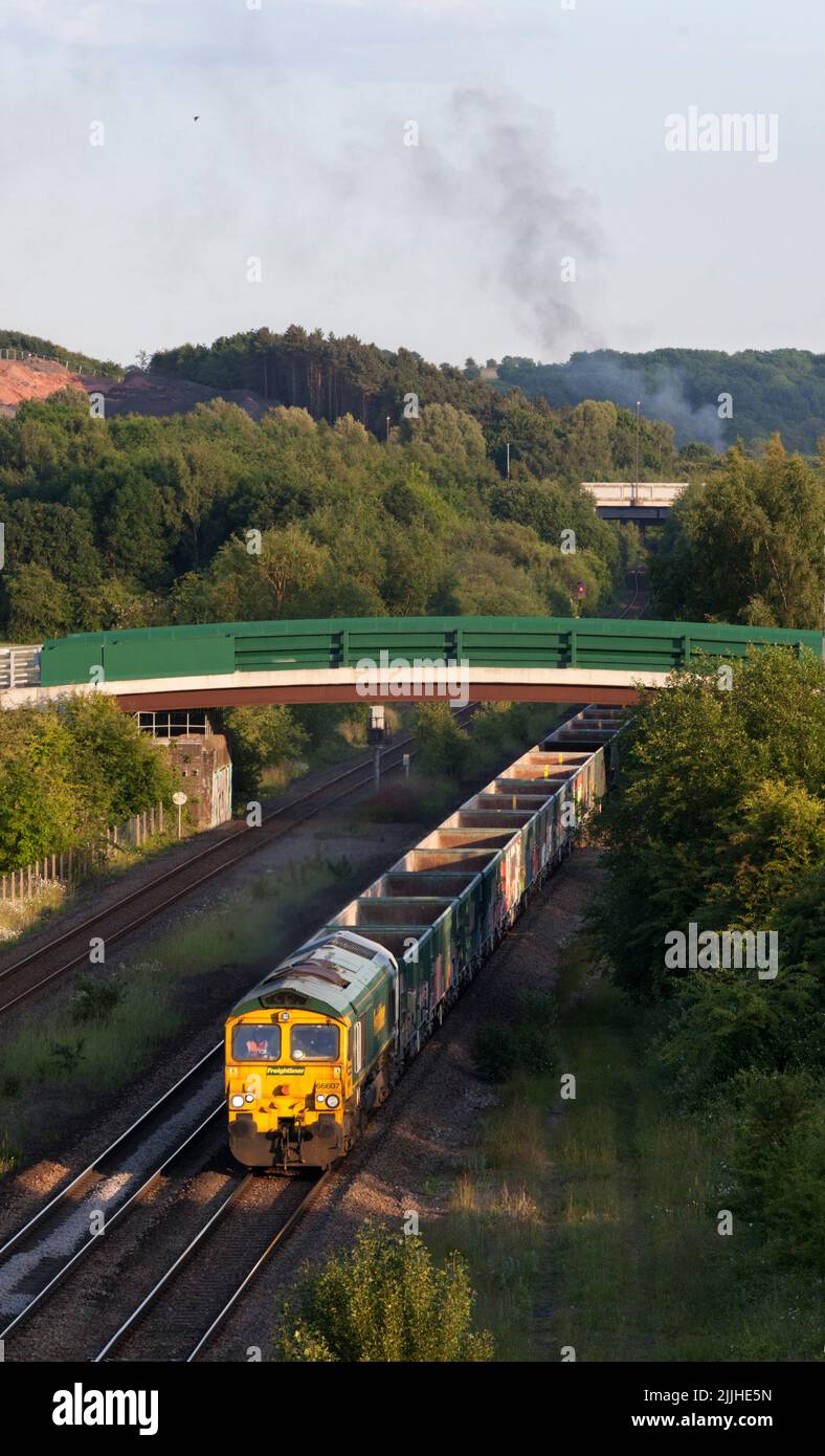 Freightliner class 66 diesel locomotive passing Bennerley in the Erewash valley, Nottinghamshire, UK with a freight train of empty aggregates wagons Stock Photo