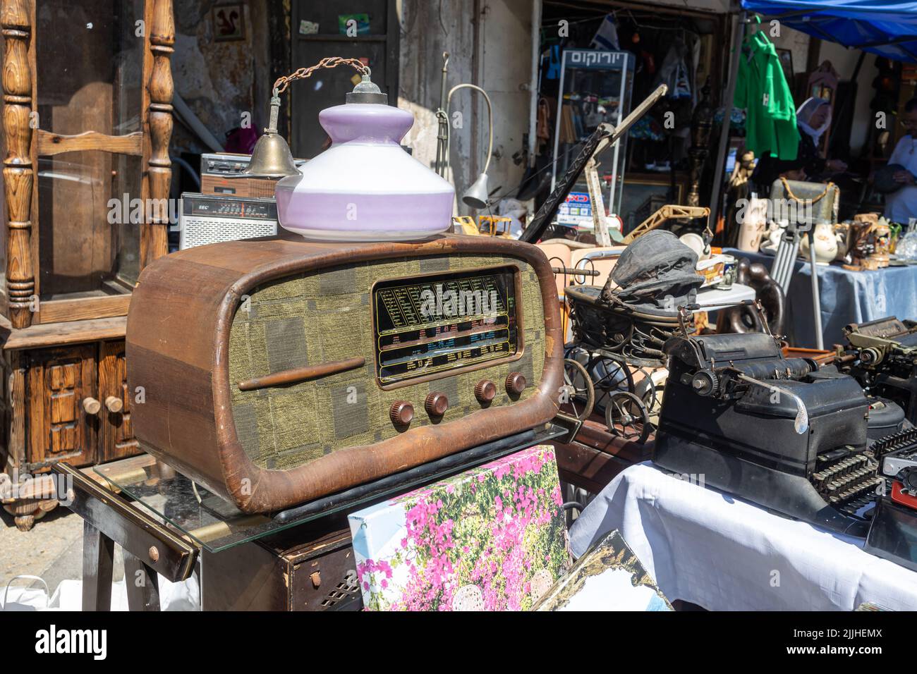 Haifa, Israel - 20 July 2022, Scene of the flea market, with sellers and shoppers, in downtown Haifa, Israel. The lamp stands on an old radiogram Stock Photo