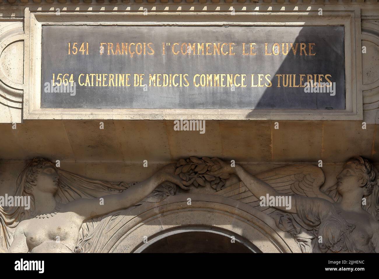 Board on the wall of Louvre palace stating that 1541 Francis I starts the Louvre and 1564 Catherine de Medici begins the Tuileries Stock Photo