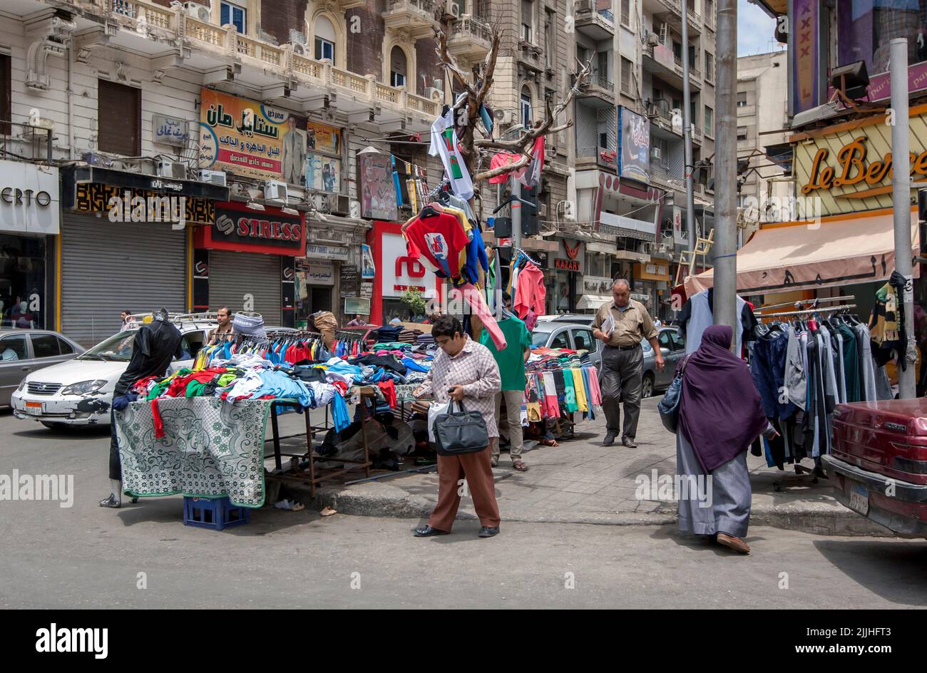 A busy street scene including a sidewalk stall selling textiles located in downtown Cairo in Egypt. Stock Photo