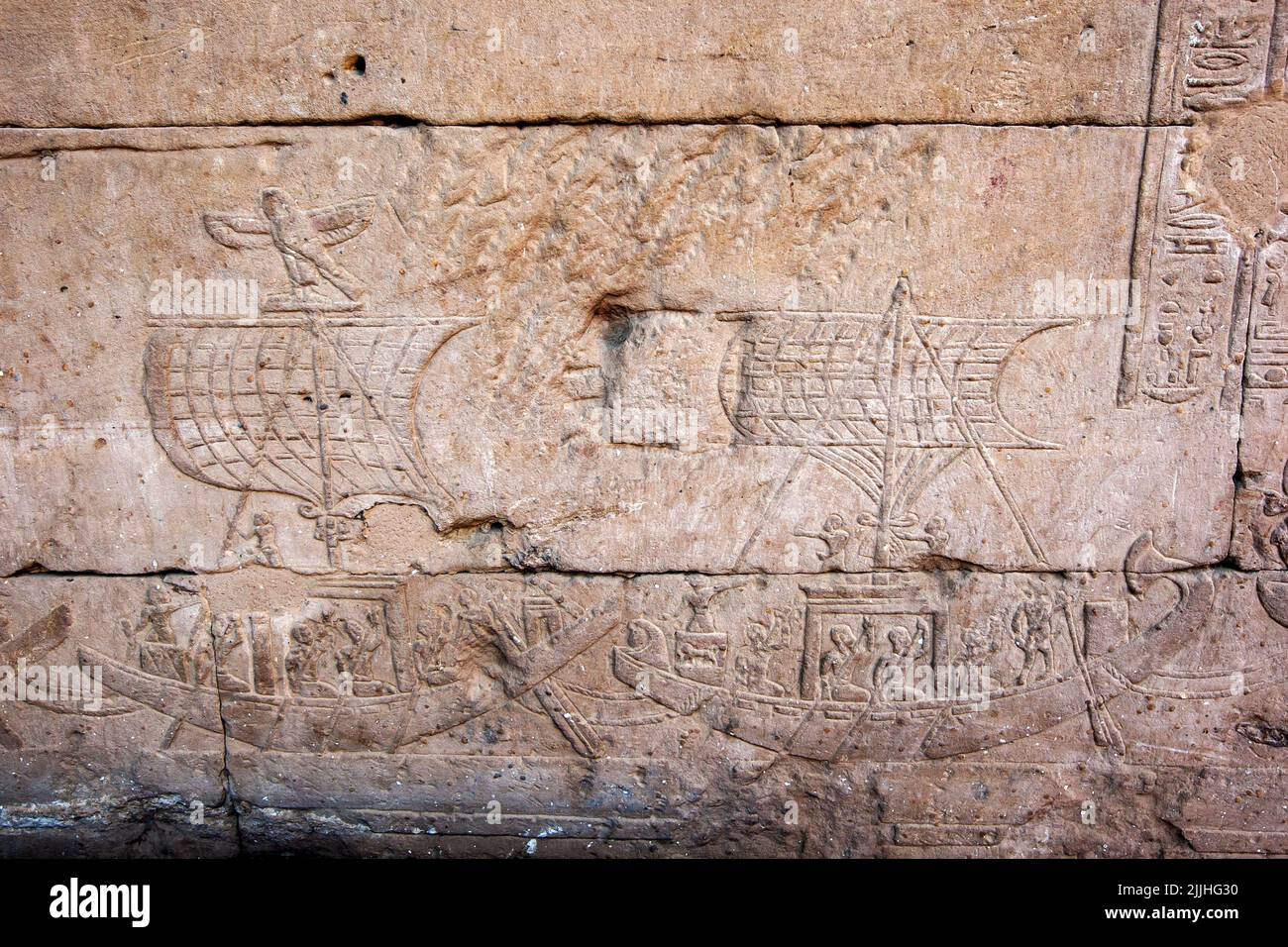 Engraved raised reliefs including sailing boats and hieroglyphics on the pylon wall inside the Temple of Horus at Edfu in central Egypt. Stock Photo