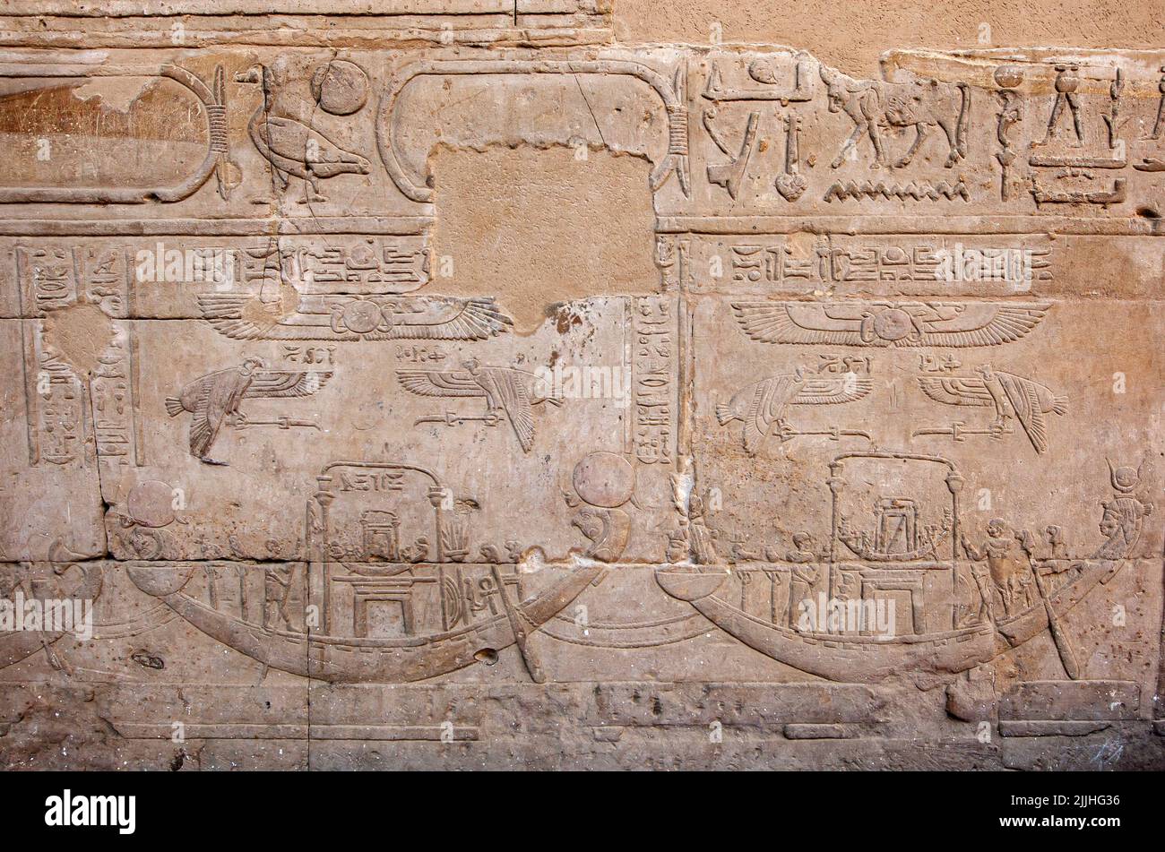 Engraved raised reliefs including boats and hieroglyphics on the pylon wall inside the Temple of Horus at Edfu in central Egypt. Stock Photo