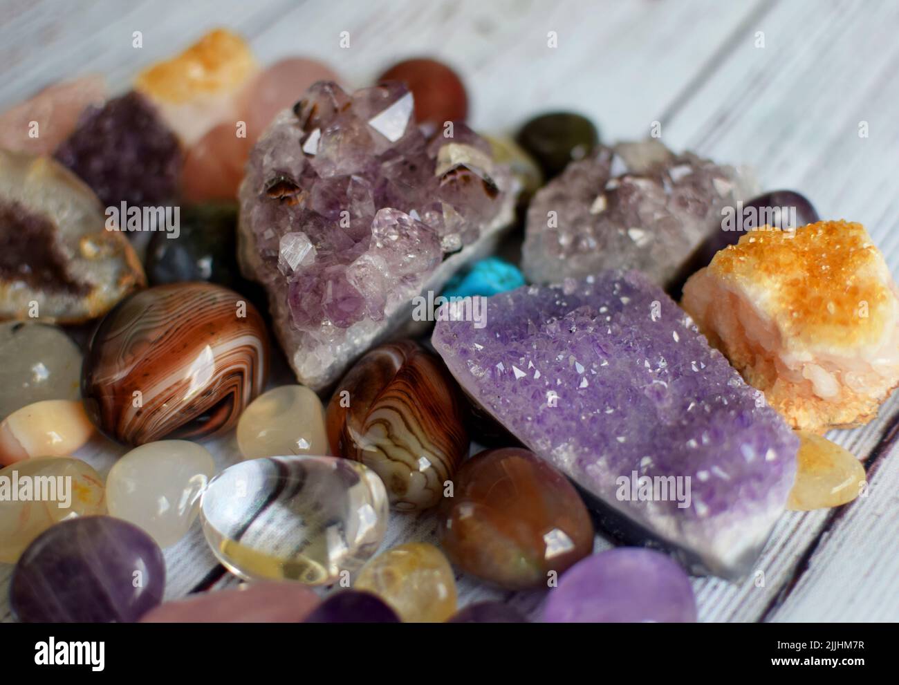 Beautiful amethyst crystals, round rose quartz stone and bostwana agate on a wooden background. Magic amulets. Stock Photo