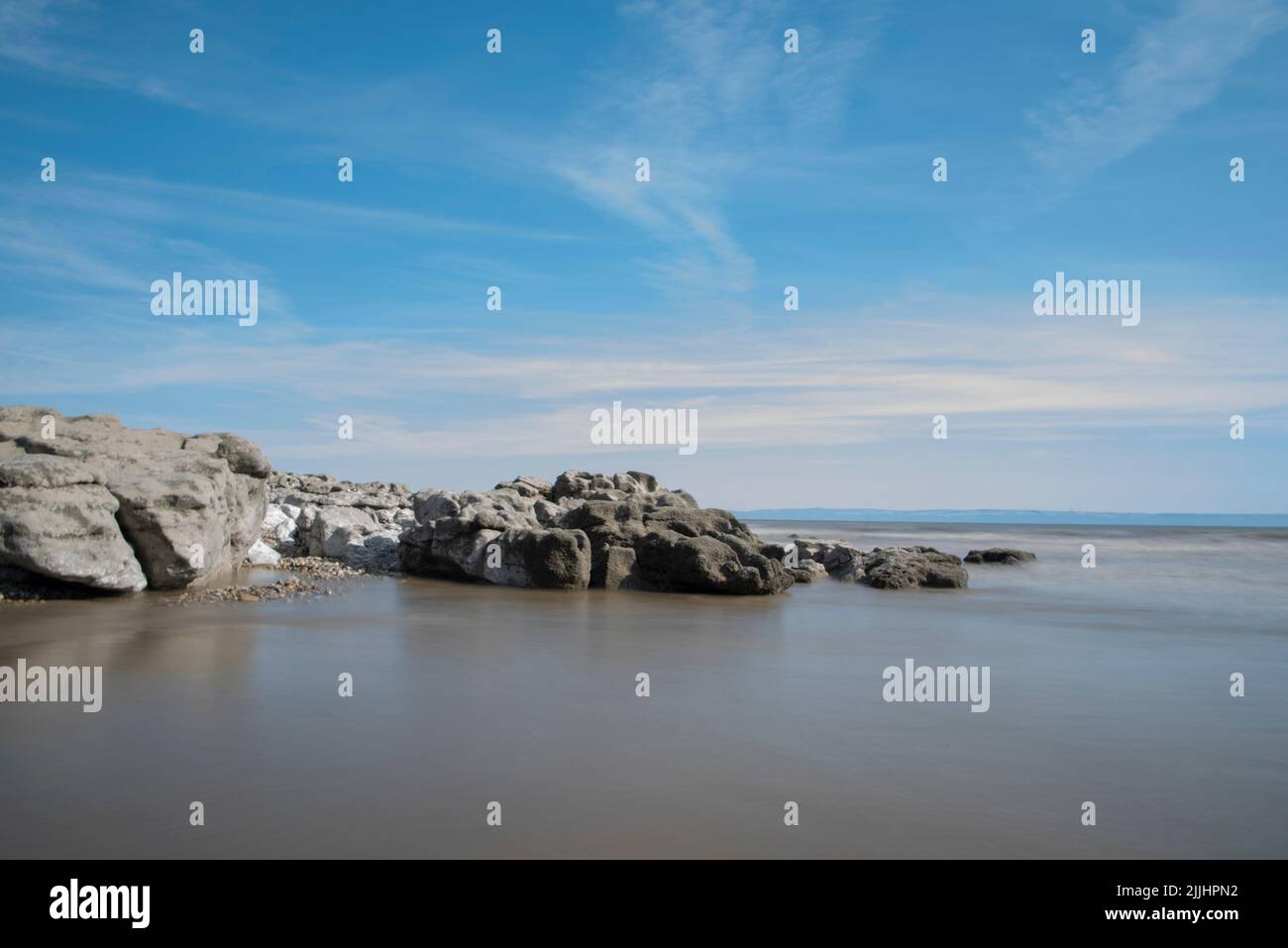 Ogmore-By-Sea Beach, Ogmore-By-Sea, Vale Of Glamorgan - Rocks, Smooth Water and Blue Skies Stock Photo